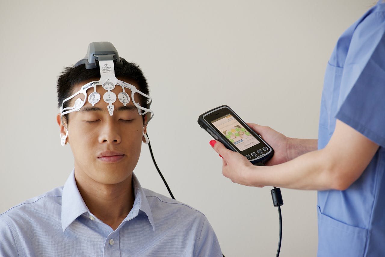why-choose-us Healthcare professional conducting an EEG examination using a Brainscope device on a male patient.